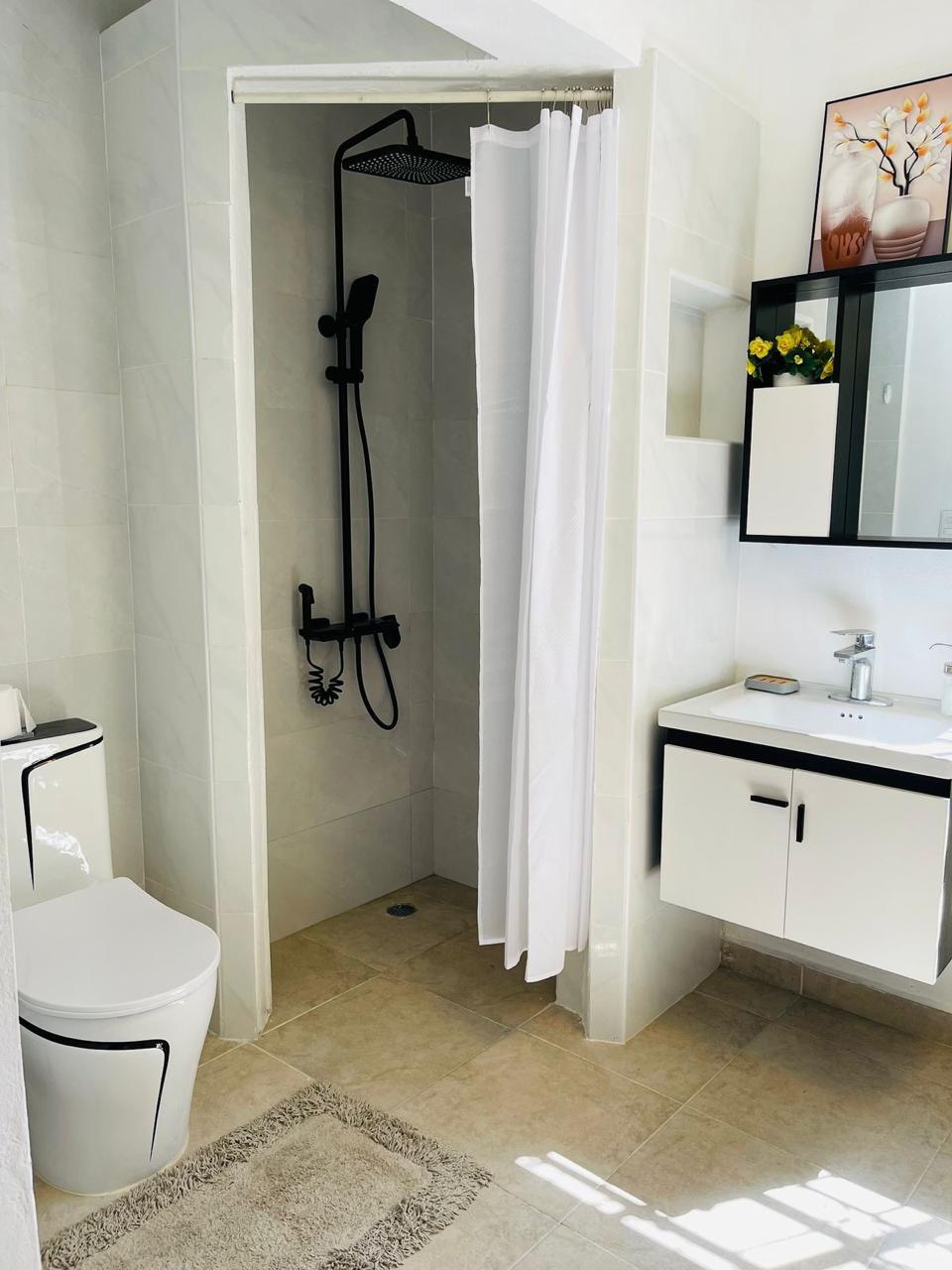 Baño completo con ducha y tocador moderno