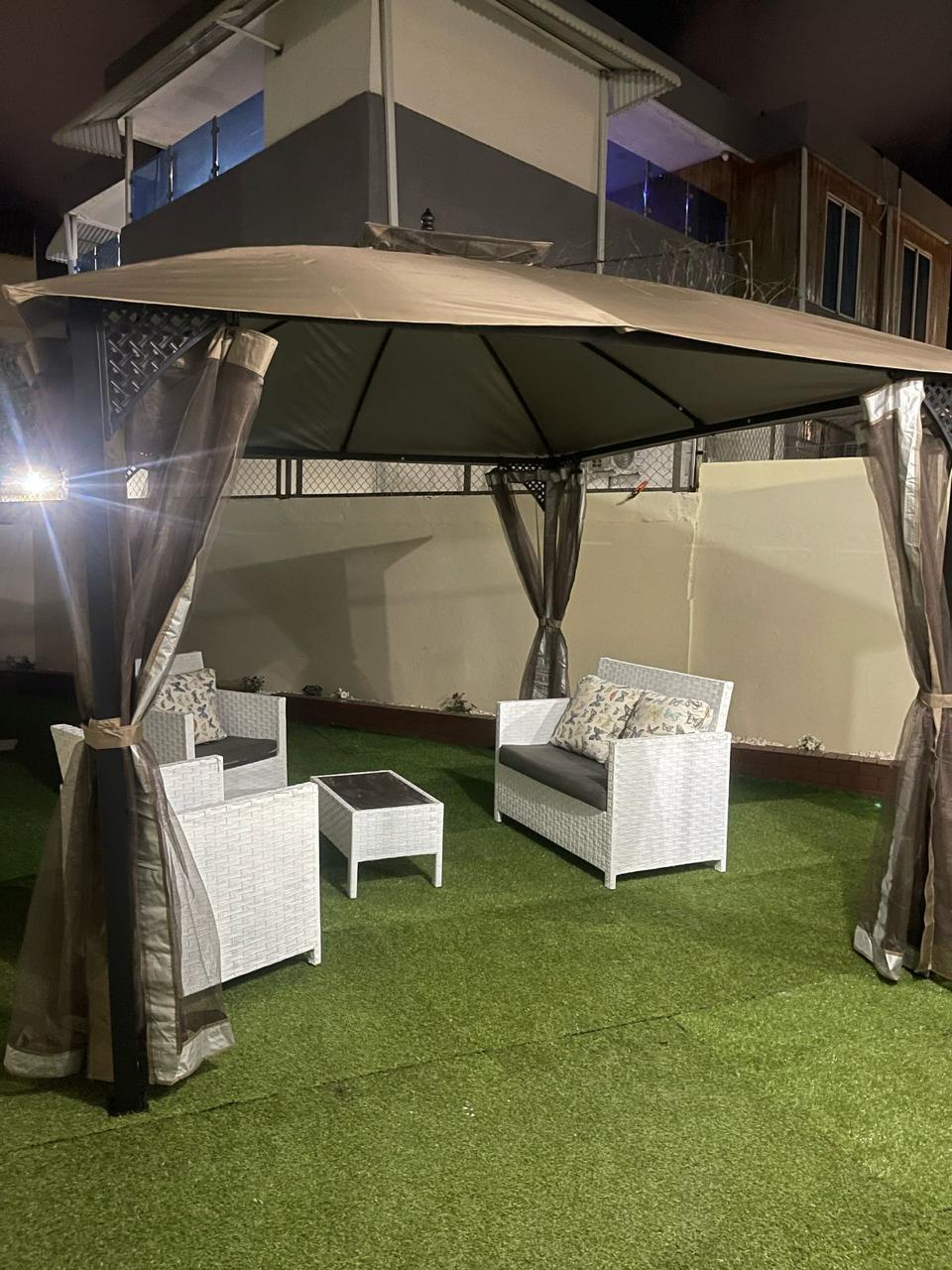 Patio exterior con gazebo y sala